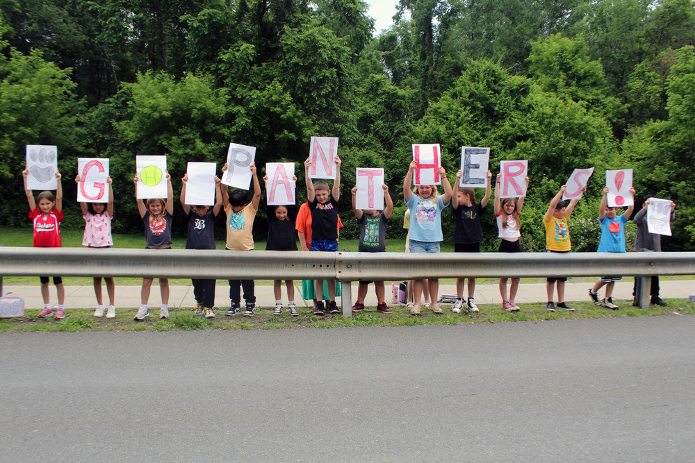 students holding up signs that spell Go Panthers!