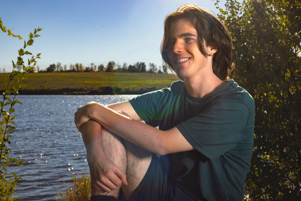 Luca Spencer sitting by pond