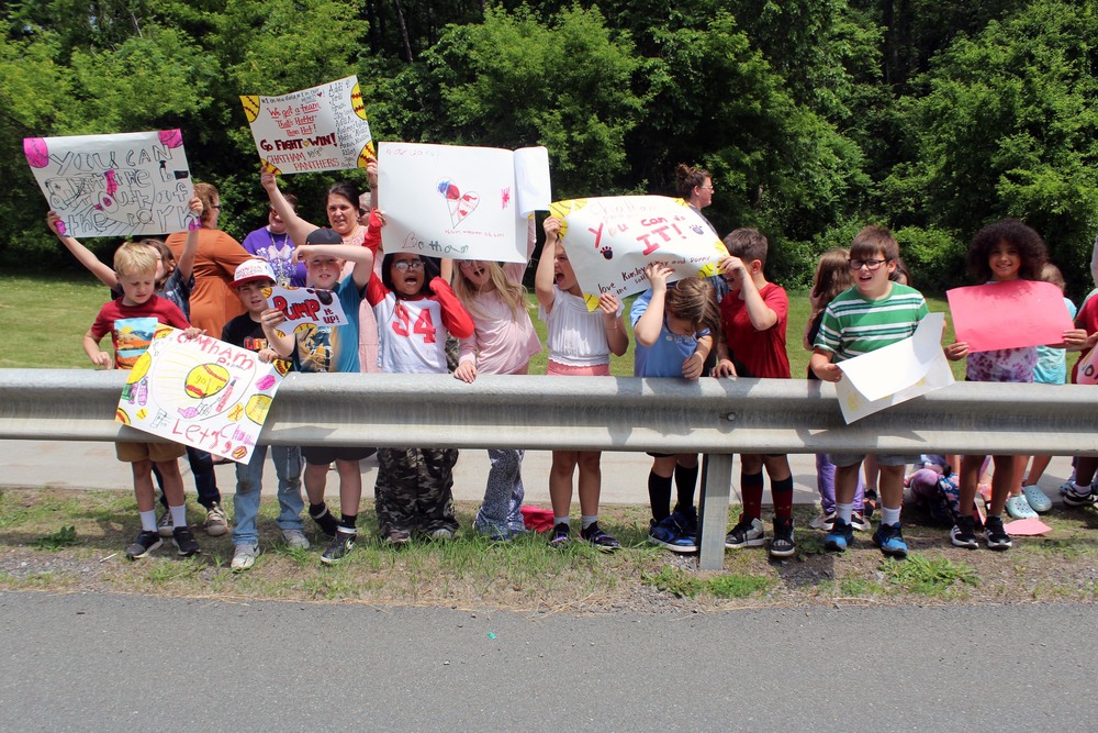 elementary age students holding signs